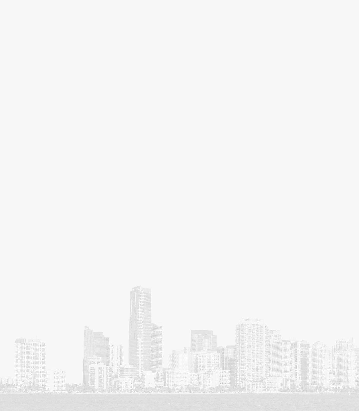 Black and white image of a coastal city skyline with high-rise buildings and calm water foreground.