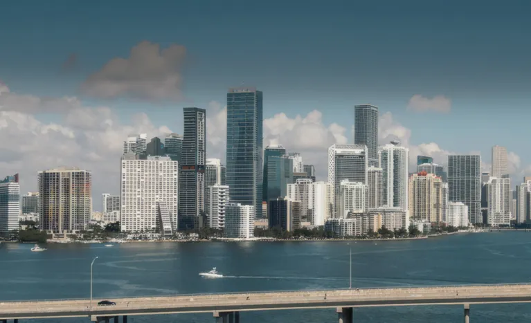 Panoramic view of a modern city skyline with high-rise buildings and a waterfront bridge.